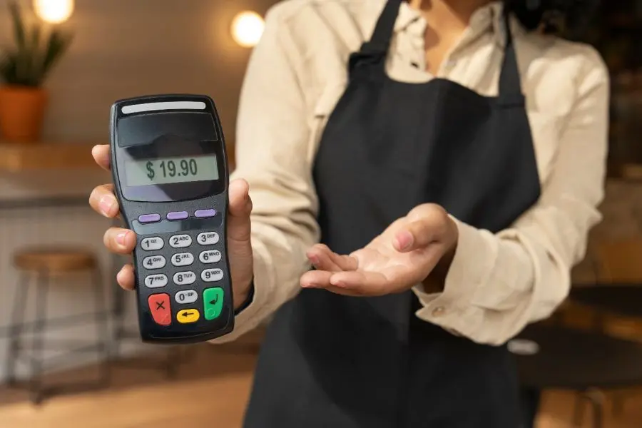 Technician operating handheld POS terminal in mobile repair shop environment