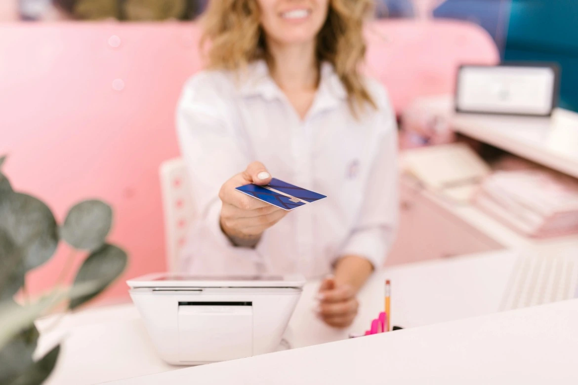 Customer holding credit card ready for payment at cell phone retail store